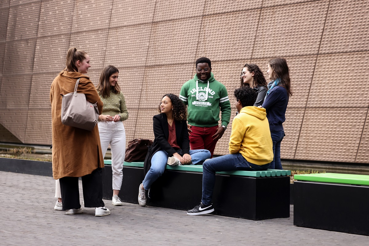 Group of students chatting outside, next to the MAE