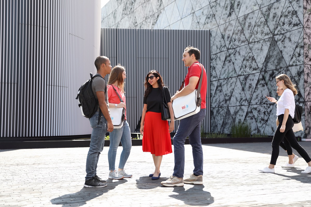 Four students in front of the LLC chatting.