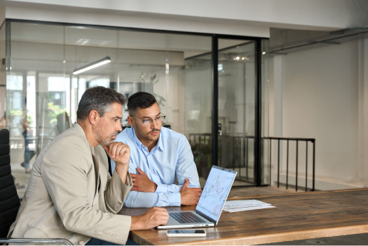 Two accountants assessing data on a laptop